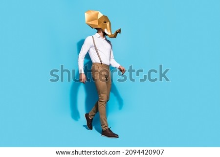 Photo of confident busy guy dressed wild animal mask walking empty space isolated blue color background