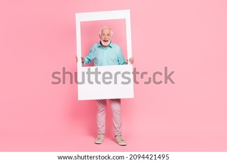 Full length photo of crazy middle aged man hold photograph border wear teal clothes isolated pastel color background
