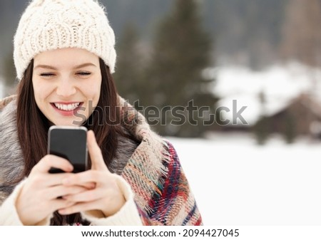 Close up of woman in knit hat text messaging with cell phone