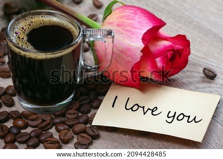 note i love you. cup of coffee, roasted coffee beans and red rose on a wooden table. romantic coffee. selective focus