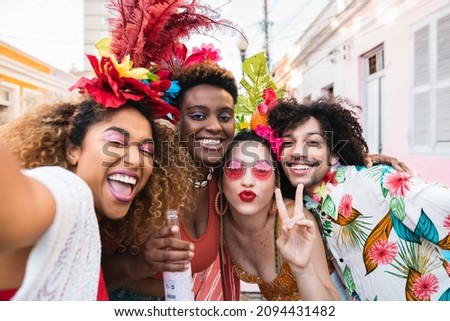 Friends in costumes have fun at carnival party in the street. Brazil holiday fun selfie with group of people together Royalty-Free Stock Photo #2094431482