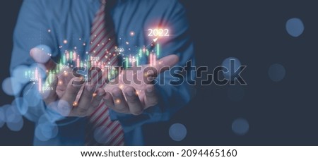 Businessman holding horizontal graph for analysis share, currency, forex, for year 2022 growth business to the future. Analysts trading share strategy analyzing from diagram graph for investment.