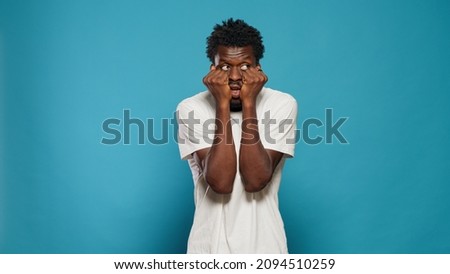 Portrait of frightened man having hands on mouth. Scared person feeling anxious and panicked in studio while looking at horror scene and scary movie. Afraid adult having terrified reaction Royalty-Free Stock Photo #2094510259