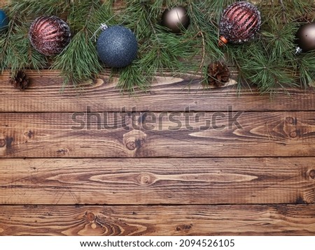 Festive traditional Christmas baubles, blue, brown balls, pine branches, on shabby old rustic wooden table. Christmas background, New Year, winter holiday concept. Copy space, top view, flat lay