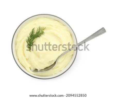 Bowl with freshly cooked homemade mashed potatoes and spoon isolated on white, top view