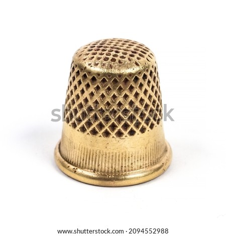 Metal thimble for sewing. Antique copper thimble on a white background. Royalty-Free Stock Photo #2094552988