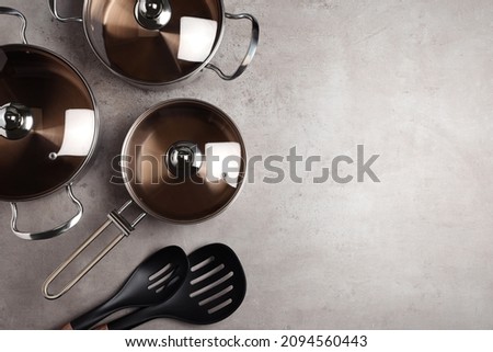 New cookware set and kitchen utensils on light grey table, flat lay. Space for text Royalty-Free Stock Photo #2094560443