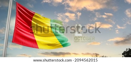 Guinea national flag cloth fabric waving on the sky with beautiful sky - Image