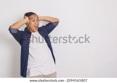 Portrait of surprised asian man, shouting, shocked, looking at copy space beside isolated on white background Royalty-Free Stock Photo #2094565807