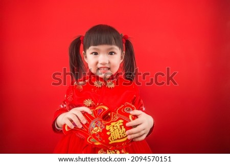 A girl celebrates Chinese New Year with a Chinese knot.  Chinese translation in the picture：Lucky fortune