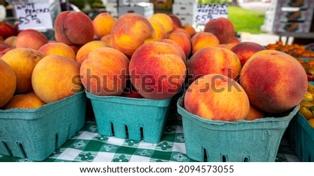 Fresh colorful peaches in cardboard crates are for sale at a Farmers Market in Oregon. Royalty-Free Stock Photo #2094573055