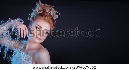 Snow Queen High Fashion Portrait over Black night Background. Young woman in creative image with silver artistic make-up. Winter holiday