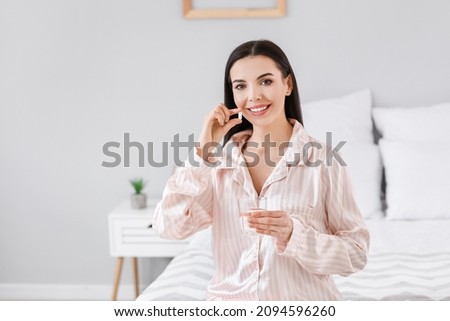 Beautiful young woman taking pills in bedroom Royalty-Free Stock Photo #2094596260
