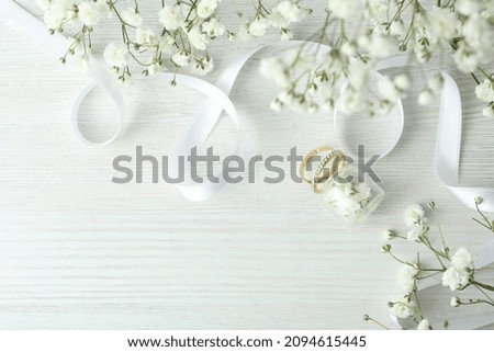 Concept of wedding accessories with wedding rings on white wooden background Royalty-Free Stock Photo #2094615445