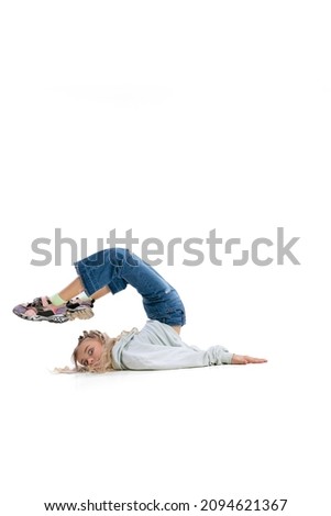 Silly mood. Cute funny little girl, flexible kid in casual clothes having fun isolated on white studio background. Concept of emotions, childhood, facial expression. Copy space for ad, design, text