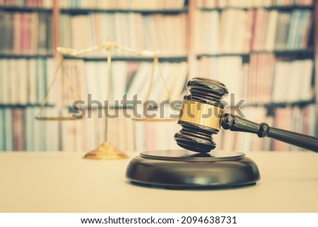 Legal office of lawyers, justice and law concept : Judge gavel or a hammer and a base used by a judge person on a desk in a courtroom with blurred weight scale of justice, bookshelf background behind	 Royalty-Free Stock Photo #2094638731