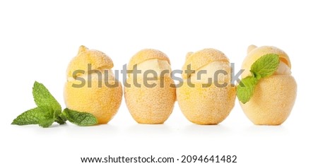Tasty ice creams in lemon peels on white background