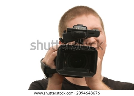 A man holding up a professional video camera on a white background. 