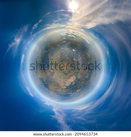 Aerial view from airplane window at high altitude of little planet earth covered with white thin layer of misty haze and distant clouds at sunset Royalty-Free Stock Photo #2094653734
