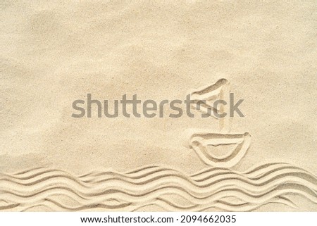 A boat on the waves painted in the sand