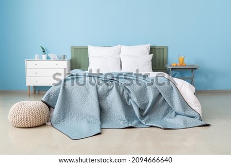 Double bed near color wall in interior of stylish bedroom Royalty-Free Stock Photo #2094666640