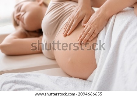 Young pregnant woman having massage in spa salon Royalty-Free Stock Photo #2094666655