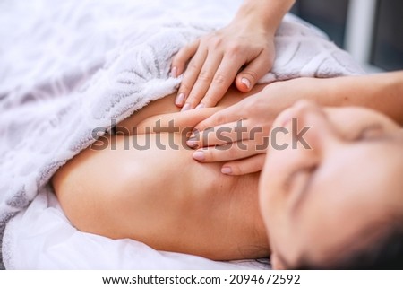 Body massage for a young woman. Alternative health methods with aromatic oils. Cosmetology procedures for face and body skin. Skin care in adulthood. Horizontal photo of people.