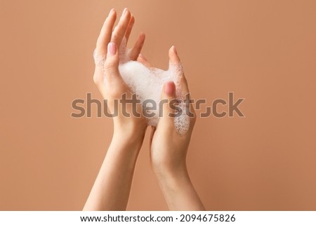 Woman washing hands with soap on color background Royalty-Free Stock Photo #2094675826