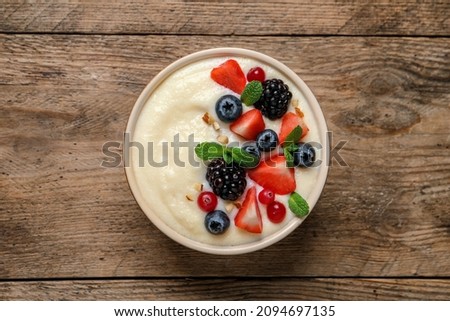 Delicious semolina pudding with berries on wooden table, top view Royalty-Free Stock Photo #2094697135