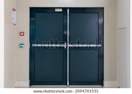 View of the closed door of the evacuation exit from the building during a fire or other cataclysm. Emergency fire exit from the building. Closed emergency exit door, for quick evacuation