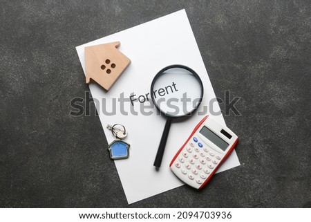 Paper with text FOR RENT, magnifier, calculator and key on black background