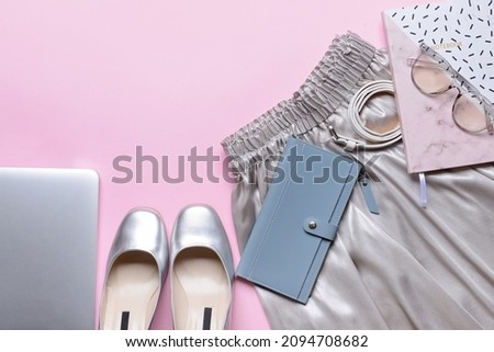 Stylish female clothes and accessories on pink background