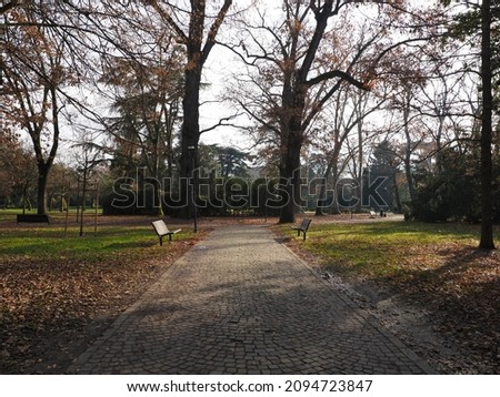Ferrara, Italy. Parco Massari, public park. Benches along the porphyry path.