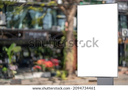 Blank white outdoor advertising stand, board mock up template. Clear street signage board placed by an outdoor dinning area of a restaurant, bakery cafe restaurant background