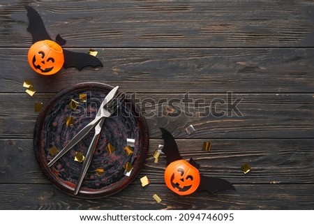 Halloween table setting with confetti on dark wooden background