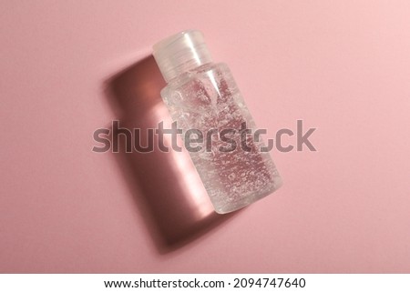 Bottle of cosmetic gel on pink background, top view