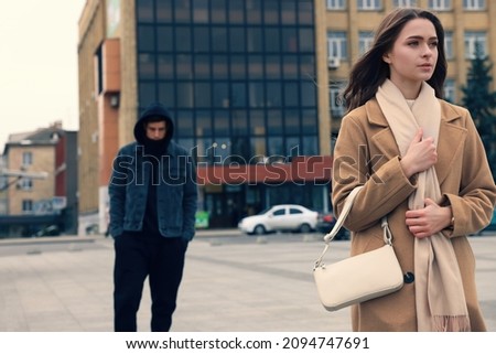 Man stalking young woman on city street Royalty-Free Stock Photo #2094747691