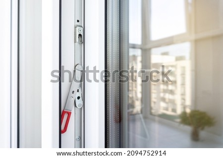 White plastic balcony door frame with fittings. Concealed drive lever close-up. Upvc windows and doors accessories and hardware. Royalty-Free Stock Photo #2094752914