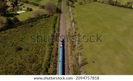Aerial shot of blue train in rural area of Buenos Aires during summer. Top down view