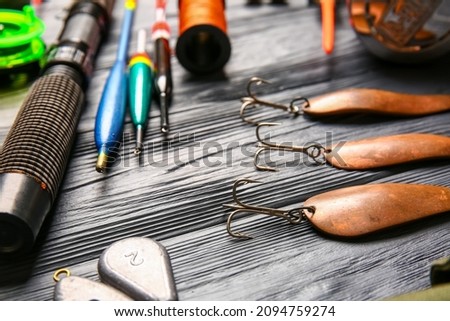Different fishing equipment on dark wooden background, closeup