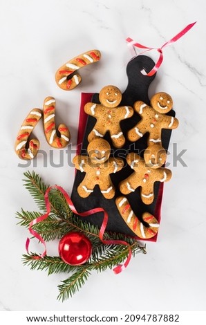 Christmas Gingerbread Man. Festive  honey ginger cookies with cinnamon and nutmeg on a serving board on a red linen napkin on a light background. Top view