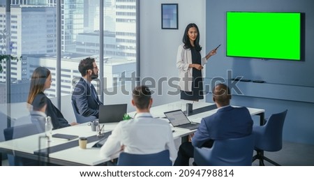 Diverse Office Conference Room Meeting: Asian Female Project Manager Uses Green Screen Chroma Key Wall TV to Present Digital Investment Opportunity for Happy Investment Team.