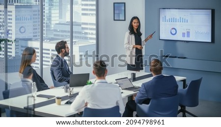 Diverse Office Conference Room Meeting: Asian Female Project Manager Presents Digital Business Expansion Strategy for Investment Team, Uses Wall TV with Big Data Analysis, e-Commerce Infographics.