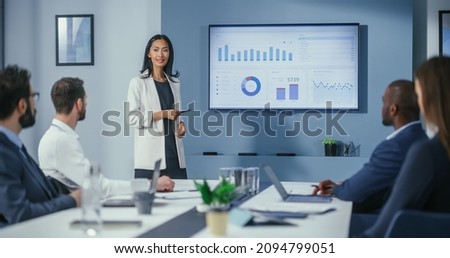 Office Conference Room Meeting: Portrait of Confident Asian Female Top Manager Presents e-Commerce Investment Strategy for Group of Digital Entrepreneurs. Wall TV with Big Data Analysis, Infographics Royalty-Free Stock Photo #2094799051