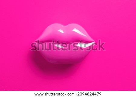 Artificial pink lips shape on pink background. Flat lay. Beauty, care, perfection concept. Minimalism