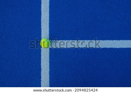 Blue paddle tennis court at night and a ball on the line. Top view. Racket sports concept, healthy sports. Royalty-Free Stock Photo #2094825424