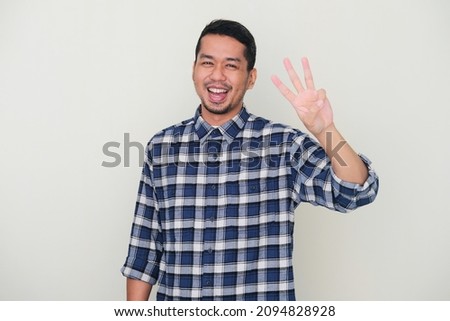 Adult Asian man smiling happy while showing three fingers sign Royalty-Free Stock Photo #2094828928