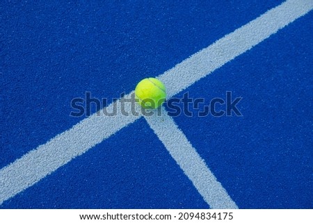 Blue paddle tennis court at night and a ball on the line. Racket sports concept, healthy sports. Royalty-Free Stock Photo #2094834175