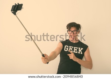 Studio shot of young Scandinavian man as nerd with eyeglasses against white background
