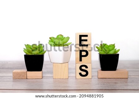 EPS - Earnings Per Share. text on wooden boards on a white background on a wooden table